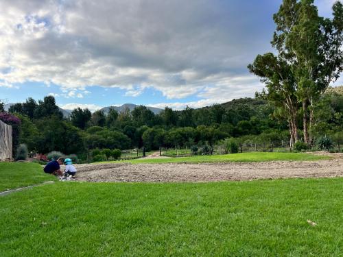 two people playing with a child in a field at Little Nyati farmstay in Somerset East