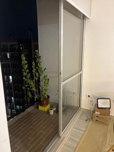 a room with a sliding glass door with a plant at Quedate con Yey in Chía