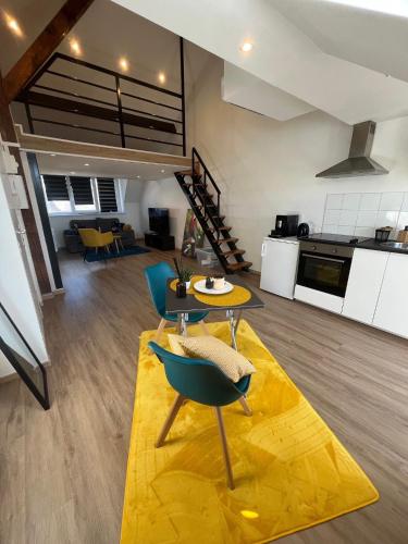 - un salon avec une table et des chaises sur un tapis jaune dans l'établissement Cesanne Amnéville proximité A31 Thermes Lux, à Amnéville
