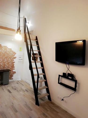 - un salon avec une télévision murale et un escalier dans l'établissement Loft cosy centre ville, à Nice
