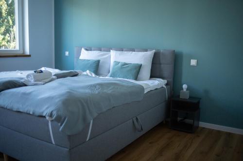 a blue bedroom with a large bed with blue walls at Best Stay Apartment Rhönblick Dietershausen in Künzell
