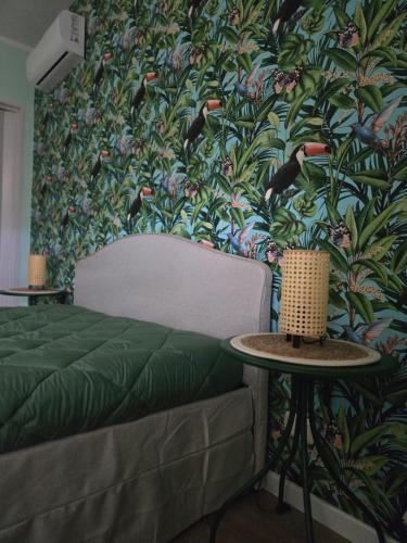 a bedroom with a green wall with a bird wallpaper at BeB Villa Ylenia in Agrigento