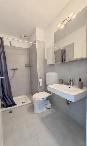 a bathroom with a toilet and a sink and a tub at Deich&Düne Nordsee -Apartment in Schillig