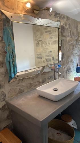 une salle de bain avec un lavabo blanc et un miroir dans l'établissement Charming stone house, à Les Matelles