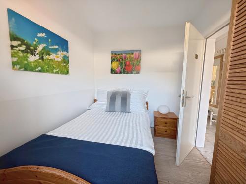 a bedroom with a blue and white bed in a room at Deich&Düne Nordsee -Apartment in Schillig