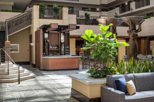 a lobby of a hotel with stairs and plants at Embassy Suites by Hilton Sacramento Riverfront Promenade in Sacramento