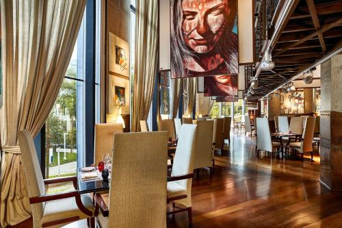 a restaurant with tables and chairs and a large portrait of a man at Hilton Sao Paulo Morumbi in Sao Paulo