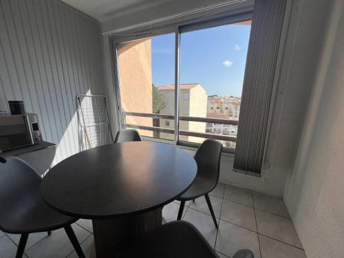 une table et des chaises dans une pièce avec une fenêtre dans l'établissement Studio Cabine Centre Port pour 4 avec Parking et Animaux admis - FR-1-749-92, au Cap d'Agde