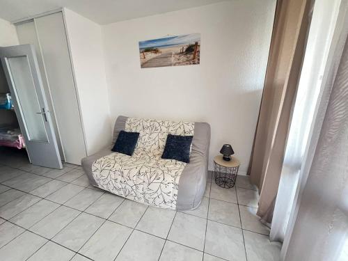 - un canapé blanc avec deux oreillers dans le salon dans l'établissement Studio Cabine Centre Port pour 4 avec Parking et Animaux admis - FR-1-749-92, au Cap d'Agde