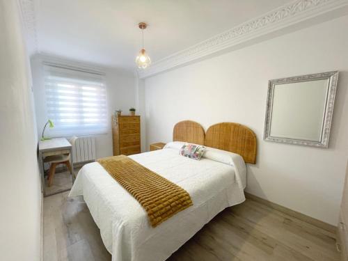 a bedroom with a bed and a table and a mirror at Lacasitadevaleria in Santander