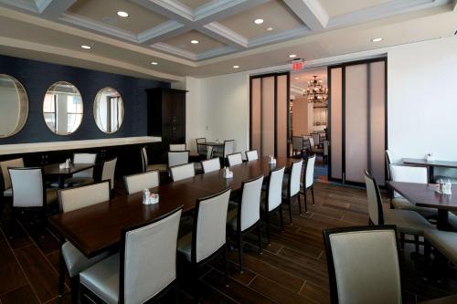 a dining room with a long table and chairs at Embassy Suites Louisville Downtown in Louisville