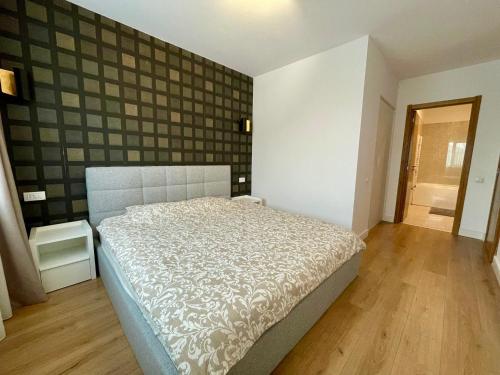a bedroom with a bed in a room with a wall at Sunrise Apartments - Onix Pipera in Bucharest