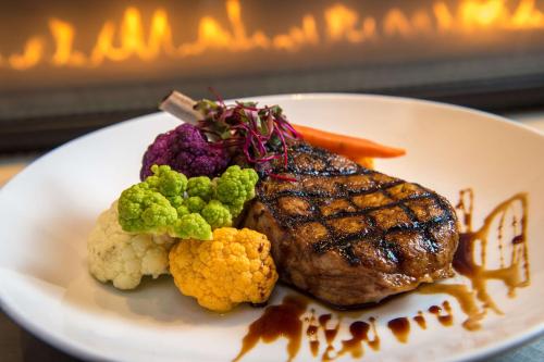 a plate of food with meat and vegetables on a table at DoubleTree by Hilton San Francisco Airport in Burlingame