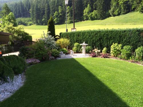 a garden with a green lawn and a fountain at Haus Magdalena Zimmer in Niklasdorf