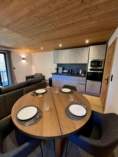 un salon avec une table en bois et une cuisine dans l'établissement La fruiterie, à Glières-Val-de-Borne