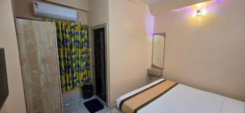 a small room with a bed and a shower at HOTELLEOs in kolkata