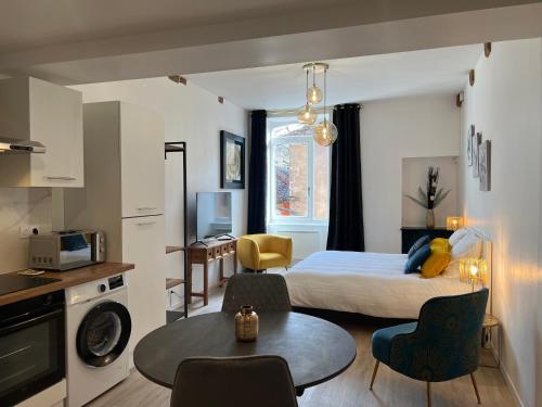 une chambre d'hôtel avec un lit, une table et des chaises dans l'établissement Bel appartement près des Halles, à Crémieu
