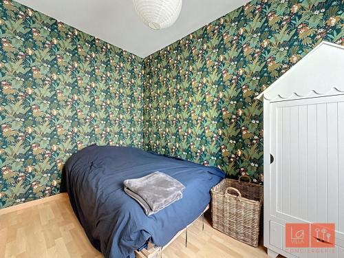 - une chambre avec un lit et du papier peint floral dans l'établissement Villa Océane, à Wimereux