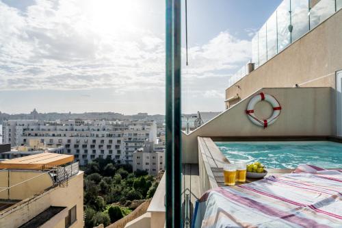 a balcony with a swimming pool on a building at ROP Penthouse & ROF Apartment by Homega, Terrace, Private Pool & Valletta Views in Sliema