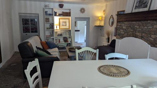 un salon avec une table blanche et un canapé dans l'établissement Maison au coeur des Baronnies, à Rioms