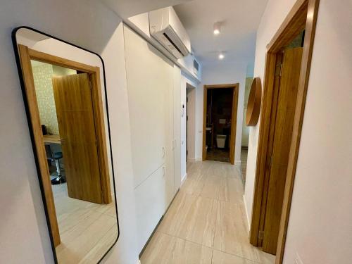 a mirror on a wall next to a hallway at Sunrise Apartments - Onix Pipera in Bucharest