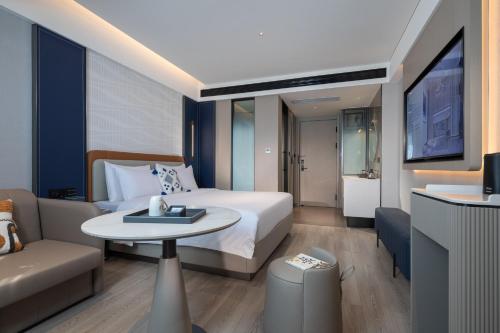 a hotel room with a bed and a table and a couch at Lijiang OKDAY HOTEL in Lijiang