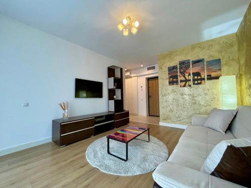 a living room with a couch and a tv at Sunrise Apartments - Onix Pipera in Bucharest