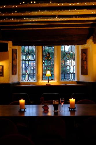 a table with two candles and a window with lights at The Old Crown Coaching Inn in Faringdon