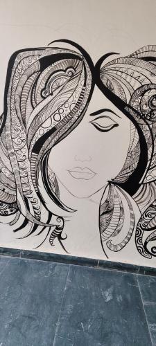 a drawing of a woman with long hair on a wall at Nainital Luxury Cotteges in Bhowāli