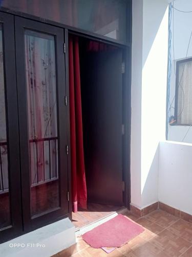 a glass door with red curtains in a room at Nainital Luxury Cotteges in Bhowāli