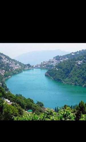 a large body of water with many boats in it at Nainital Luxury Cotteges in Bhowāli