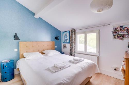 une chambre avec un grand lit avec deux serviettes dessus dans l'établissement Maison familiale climatisée avec piscine, à Bordeaux