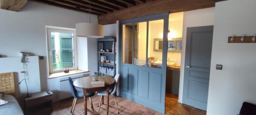 Cette chambre comprend une table et une salle de bains pourvue d'un lavabo. dans l'établissement La Coquille, chambre douillette auprès d'un élevage d'escargots, à Ouroux-sous-le-Bois-Sainte-Marie