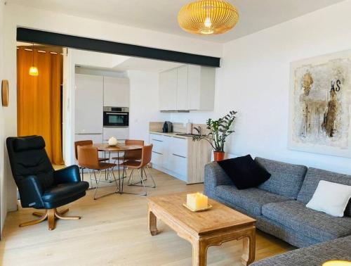 un salon avec un canapé et une table et une cuisine dans l'établissement La Maréchale, à La Rochelle