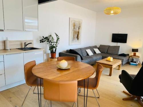 Il comprend une cuisine et un salon avec une table en bois. dans l'établissement La Maréchale, à La Rochelle