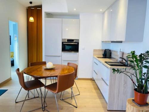 une cuisine avec une table et des chaises dans une cuisine dans l'établissement La Maréchale, à La Rochelle