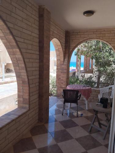 a patio with arches and a table and chairs at Chalet ElGammal in Marsa Matruh
