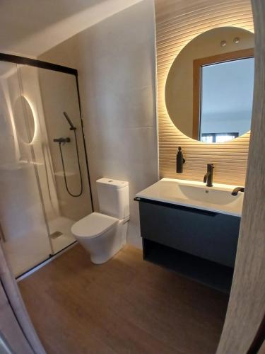 a bathroom with a toilet and a sink and a mirror at Kalea Elysivm in Alcalá del Júcar
