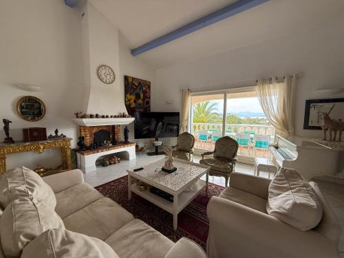 un salon avec un canapé et une cheminée dans l'établissement Villa BLUESKY - en bord de mer - Vue Panoramique sur la Mer, à Saint-Peïre-sur-Mer