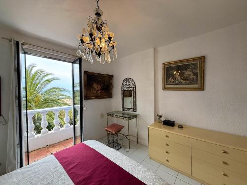 une chambre avec un lit et un lustre dans l'établissement Villa BLUESKY - en bord de mer - Vue Panoramique sur la Mer, à Saint-Peïre-sur-Mer