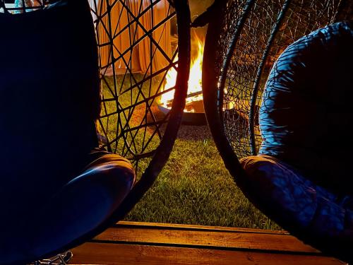 a view of a chair in front of a fire at La Clé des Champs - Studio PiscineSPA-Sauna au jardin tropical idyllique et bucolique in Jouarre
