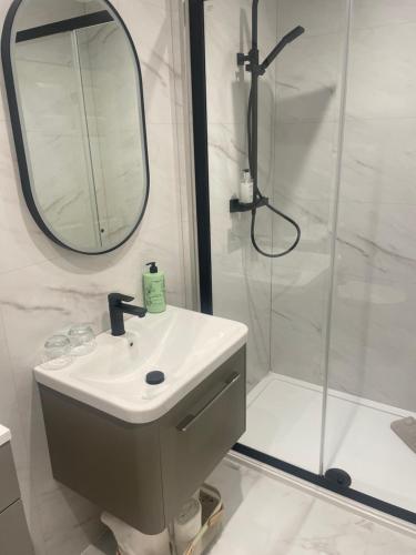 a bathroom with a sink and a shower with a mirror at Abbey House B & B in Penrith