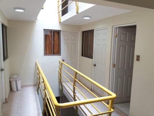 a hallway with a yellow railing and a door at Hotel Los Angeles Iquique in Iquique