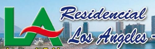 a sign for a hotel with a city in the background at Hotel Los Angeles Iquique in Iquique