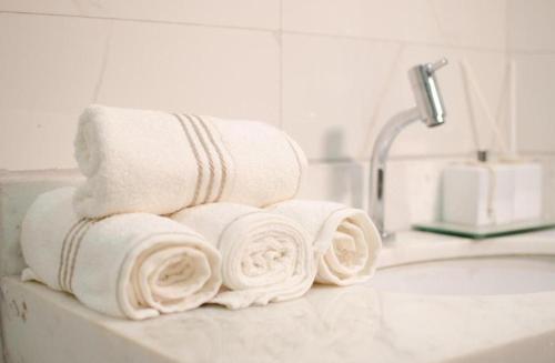 a pile of towels sitting on top of a bathroom sink at William santos Garcia in Natal