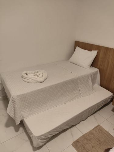 a bed with a white sheets and a pillow at William santos Garcia in Natal