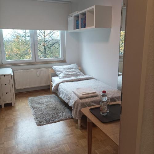 a small bedroom with a bed and a table at BS Business Travelling Hannover City in Hannover