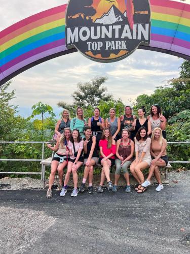 a group of people sitting on a bench under a rainbow at Mountain Top Park Hotel in Quepos