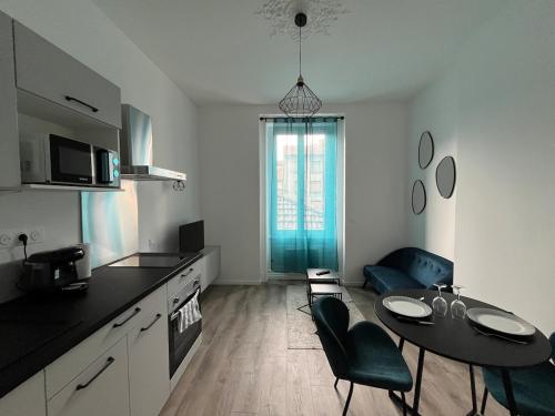 une cuisine avec une table et des chaises dans une pièce dans l'établissement T2 Confort et moderne au Cœur de la Ville, à Saint-Étienne