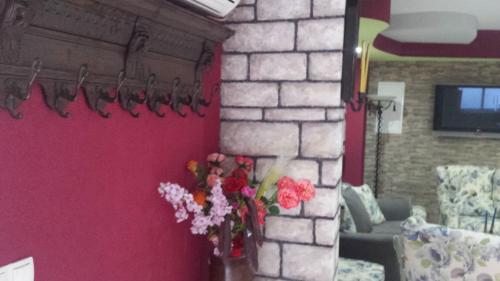 a vase of flowers on a wall in a room at Hotel Villa Nadin in Mostar